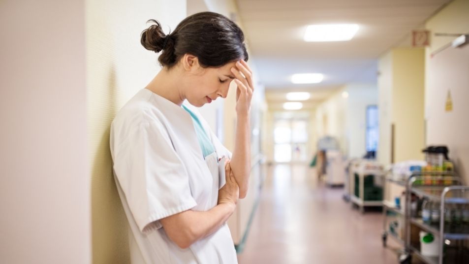 Photo of doctor with head in hand